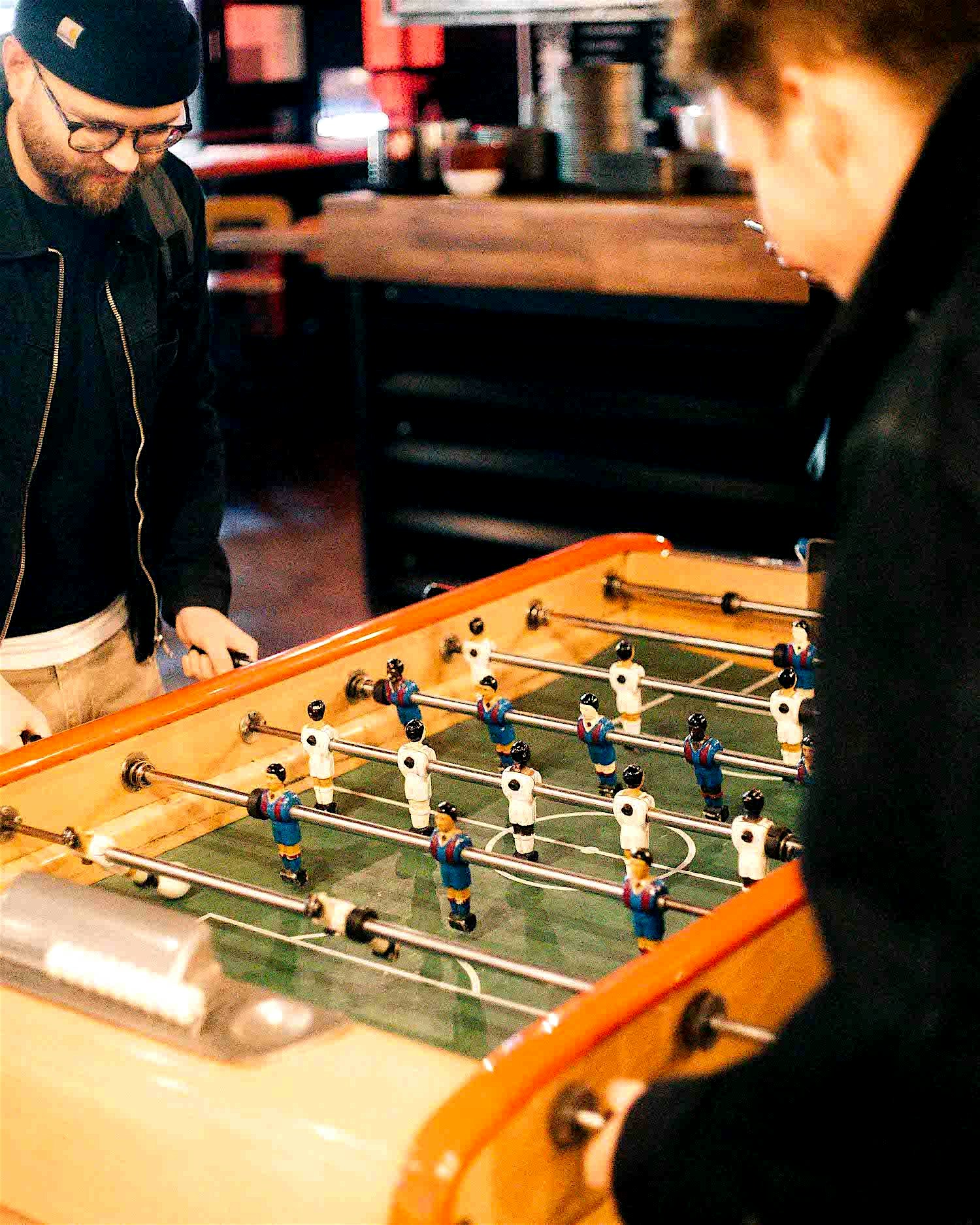 Two men play table football at a bar in Shoreditch