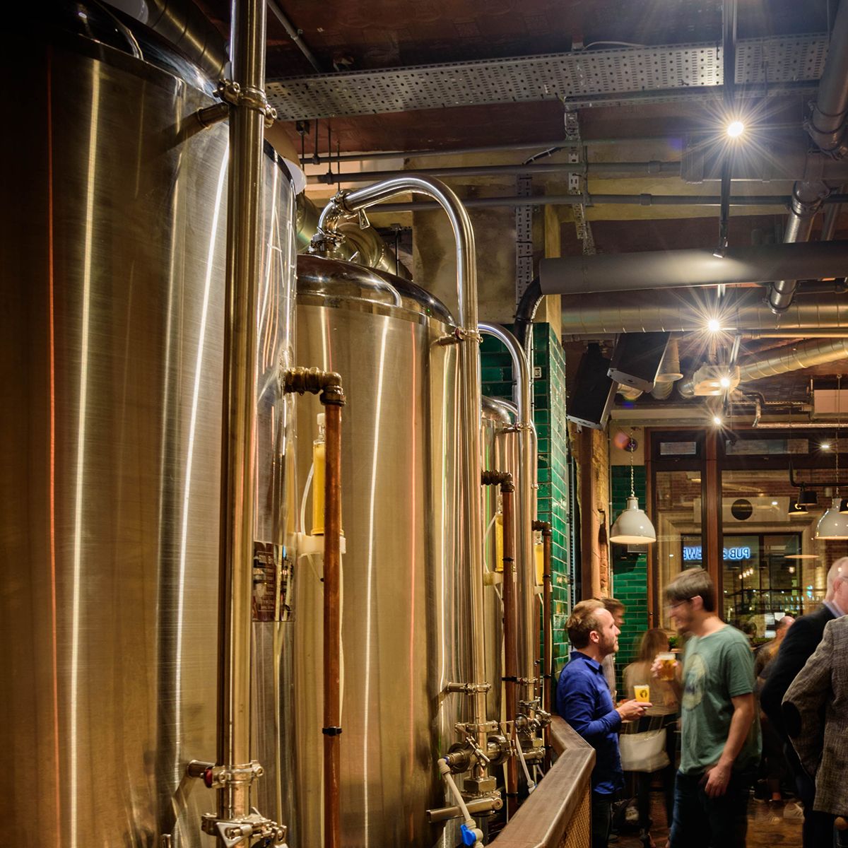 Internal brewing tanks full of beer at the Long Arm pub