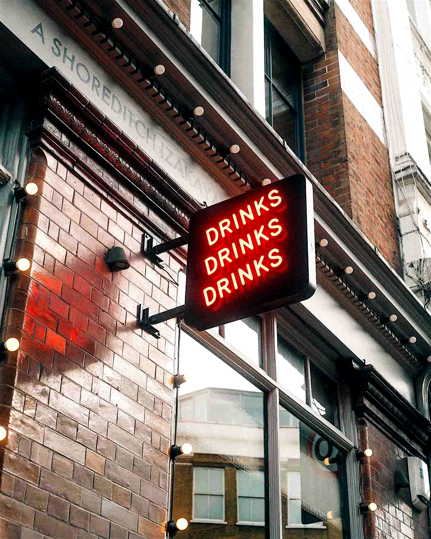 Shoreditch sign displays the words 'drinks drinks drinks'